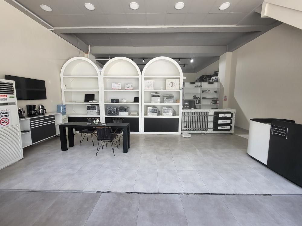 The bright interior of our Avcılar service point: arched white shelving, a waiting table and the reception counter on the right