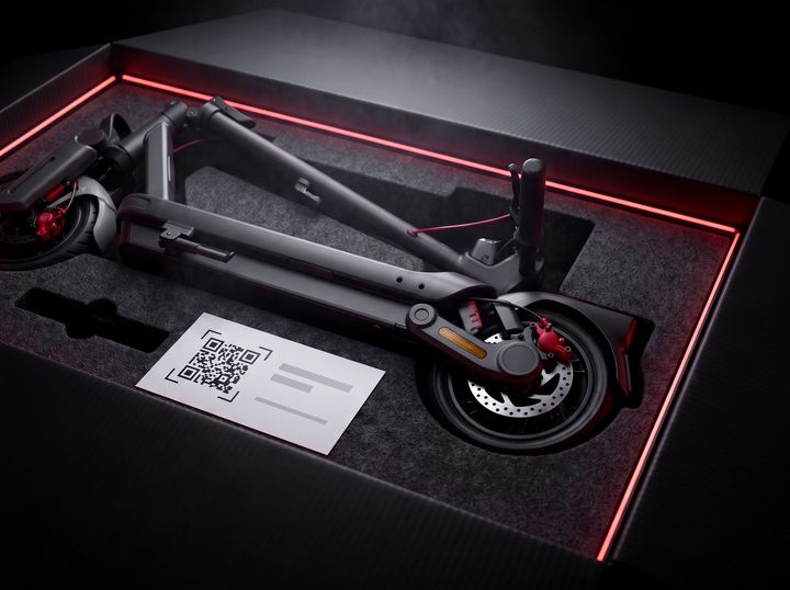 Katlanmış scooter, üzerinde QR kodlu kargo formu olan bir kutunun içinde